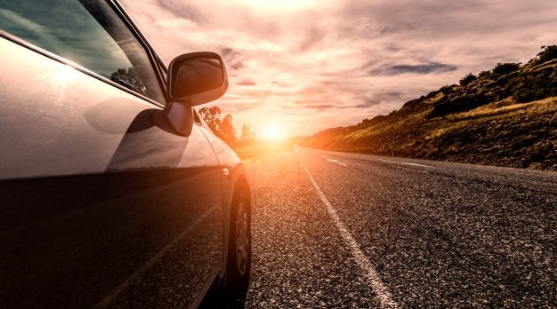vehículo circulando por la carretera al atardecer