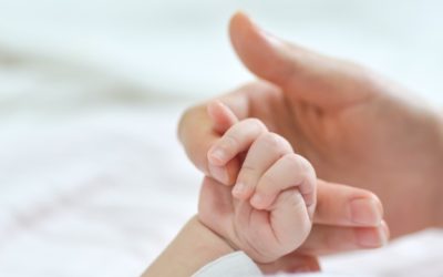 madre cogiendo de la mano a su bebé