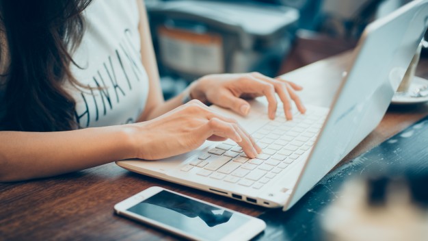 mujer escribiendo en portatil
