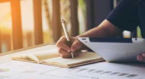 persona rellenando documentación e informes de empresa